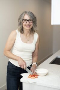 A woman cutting strawberries demonstrating healthy eating habits.