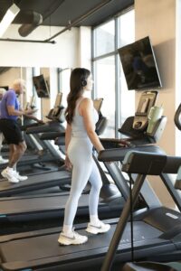 A female walking on a treadmill at an incline to demonstrate low-intensity steady-state cardio.